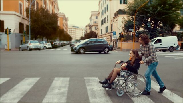 push a wheelchair-woman who is paralyzed with boyfriend pushing wheelchair