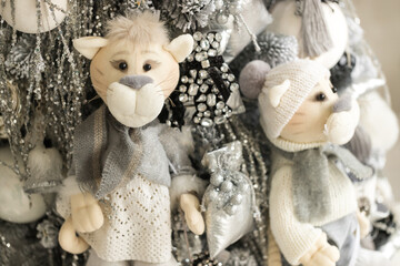 Close up of gray-white Christmas tree with soft tigers, jewelry toys, and garlands