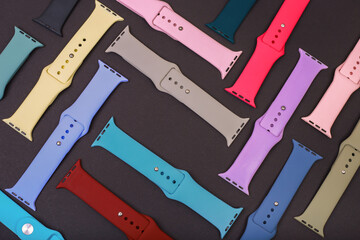 Colorful silicone straps for smart watches on a black background. Flat lay, different straps for...