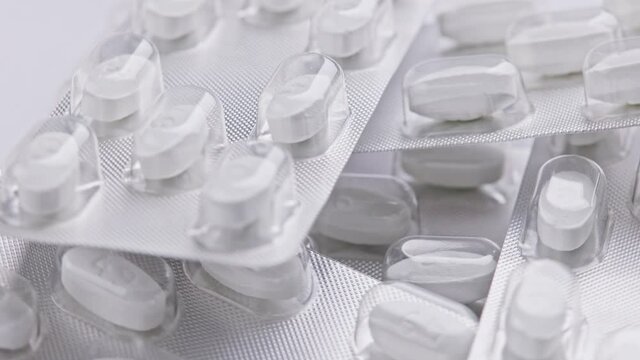 white tablet oval tablets blisters close-up looped spinning or rotating macro background