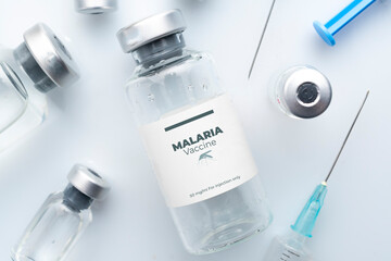 Malaria vaccine concept: vials and syringes on a white plane - obrazy, fototapety, plakaty