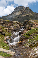 Fototapeta na wymiar Vals, Switzerland, August 21, 2021 Little waterfall in the alps