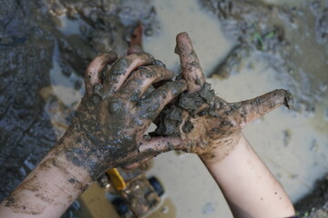 children's hands playing in the mud