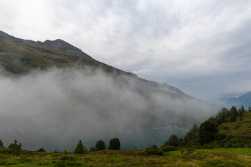 Fototapeta na wymiar Vals, Switzerland, August 22, 2021 Fog in the morning at the mount Zervreila