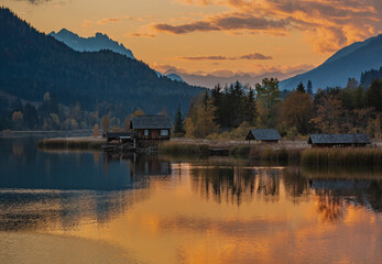 Fototapeta na wymiar Weissensee, Austria small wooden boat house reflected in the lake at sunset