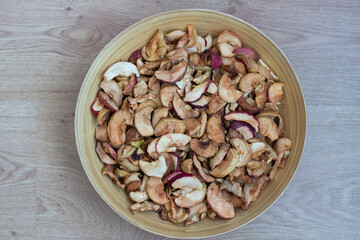 Dried apples in a plate close-up. Dried fruits from apples are in a wooden plate