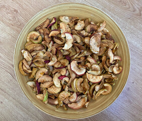 Dried apples in a plate close-up. Dried fruits from apples are in a wooden plate