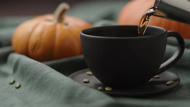 Slow motion making spiced pumpkin latte in black cup, pour spiced syrup