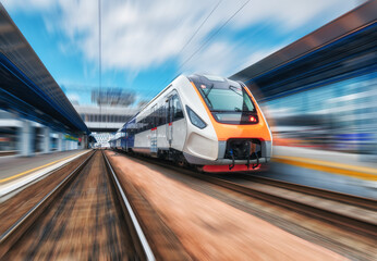 Naklejka na ściany i meble High speed train in motion on the railway station at sunset