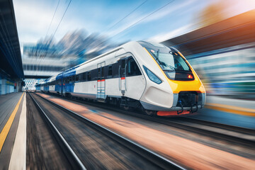 High speed train in motion on the railway station at sunset - obrazy, fototapety, plakaty
