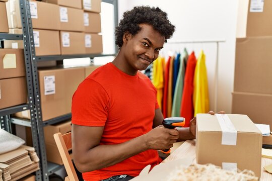 Young south east man using barcode reader device working at storehouse