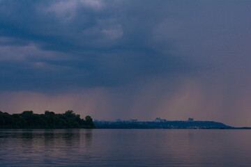 stormy sky over blue water surface. storm clouds above the sea, thunderstorm clouds over the river
