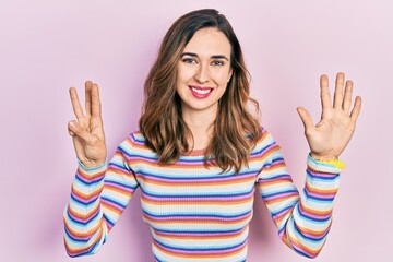 Young hispanic girl wearing casual clothes showing and pointing up with fingers number eight while smiling confident and happy.