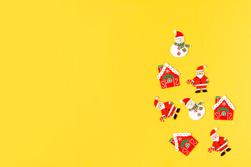 Top view of Christmas and New Year wood decoration on yellow background. Flat lay Xmas red toys with copy space