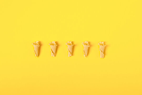 flat lay campanelle pasta on yellow background with copy space
