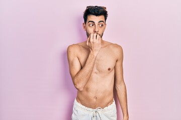 Fototapeta premium Young hispanic man wearing swimwear shirtless looking stressed and nervous with hands on mouth biting nails. anxiety problem.