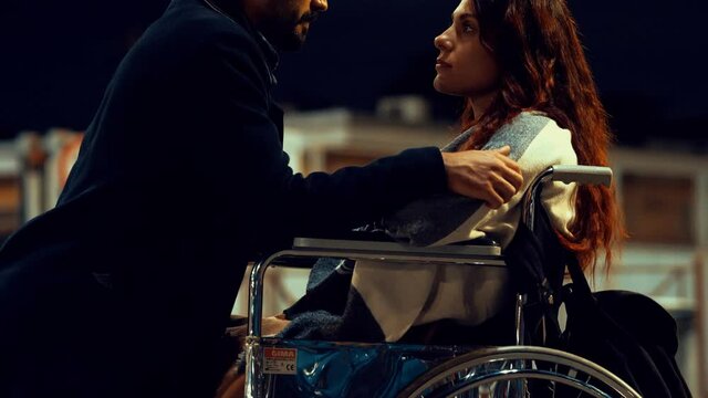 romantic kiss in the moonlight between a young man and a woman with disabilities