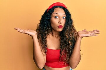 Young latin woman wearing casual clothes clueless and confused with open arms, no idea and doubtful face.