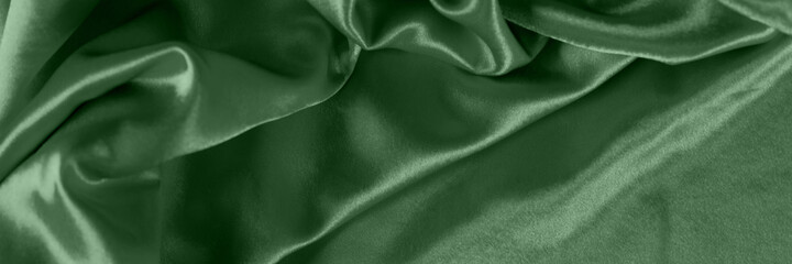 Elegant bright basil satin with waves. Fabric backdrop, view from above. Luxury cloth texture. Prefect as an abstract background with copy space, close-up.