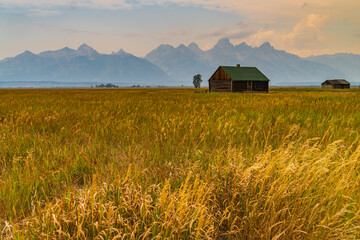 log cabin on Mormon Row historic district  with the Teton Mountain Range in the background 
