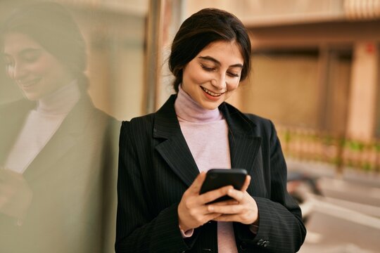 Young beautiful businesswoman smiling happy using smartphone at the city.