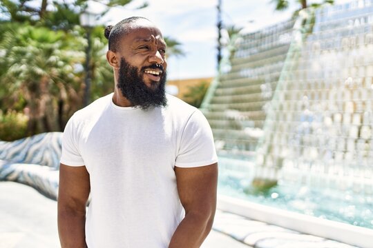 Handsome african american man with beard wearing casual white t shirt outdoors on a sunny day