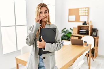 Obraz premium Blonde business woman at the office mouth and lips shut as zip with fingers. secret and silent, taboo talking