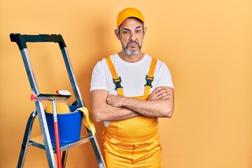 Handsome middle age man with grey hair window cleaner crossing arms depressed and worry for distress, crying angry and afraid. sad expression.