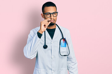 Young african american man wearing doctor uniform and stethoscope mouth and lips shut as zip with...