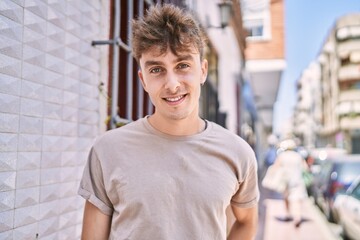 Obraz premium Young caucasian man smiling happy standing at the city.