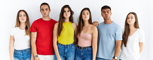 Group of people wearing casual clothes standing over isolated background puffing cheeks with funny...