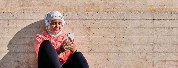 Muslim young woman with headphones taking a break