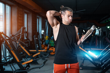 athlete student studying in gym for personal trainer or instructor with book