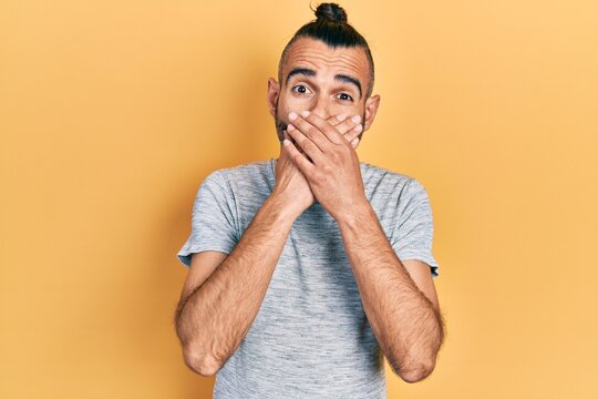 Young hispanic man wearing casual clothes shocked covering mouth with hands for mistake. secret concept.