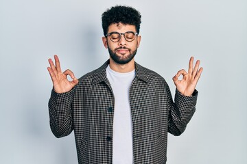 Young arab man with beard wearing glasses relax and smiling with eyes closed doing meditation gesture with fingers. yoga concept.