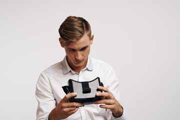 Cheerful man virtual reality glasses high-tech simulator light background