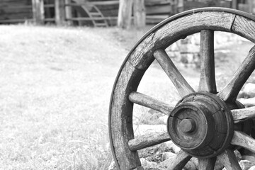 Grayscale shot of an old wooden wheel outdoors
