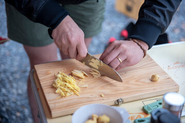 Cutting ginger on wooden cutting board for camp cooking