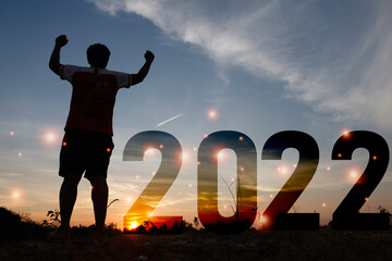 Happy new year Silhouette sunset background.A man standing next to 2022.new year,success,2022, Photo Silhouette and new year  concept idea.