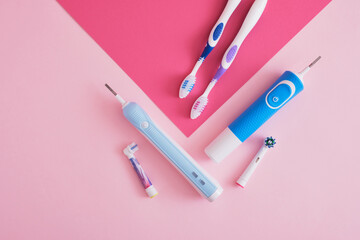 assorted toothbrushes on pink background, electric toothbrushes or plastic toothbrushes