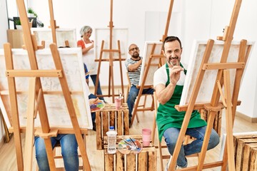 Group of middle age draw students smiling happy drawing at art studio.