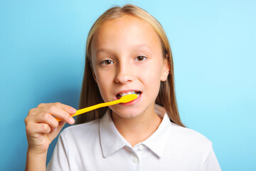 Girl in a good mood is brushing her teeth