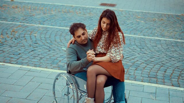 tenderness, love-young man using wheelchair in tender attitude with girlfriend