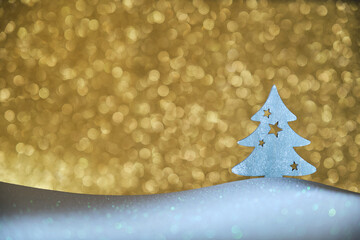 christmas tree figure on white surface and shiny golden background