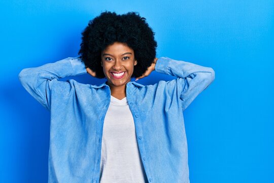 Young african american woman wearing casual clothes relaxing and stretching, arms and hands behind head and neck smiling happy