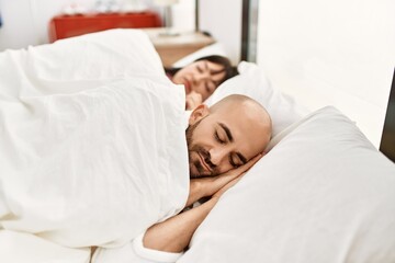 Fototapeta na wymiar Young hispanic couple sleeping on the bed at bedroom.