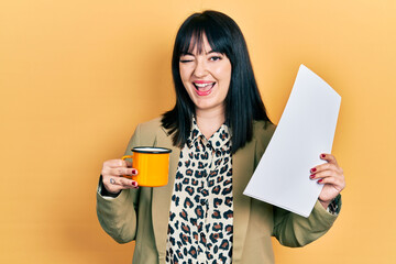 Young hispanic woman wearing business style drinking cup of coffee winking looking at the camera with sexy expression, cheerful and happy face.