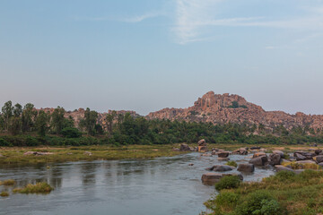 Fototapeta na wymiar インド　ハンピのトゥンガバドラ川沿いの夕景と岩山
