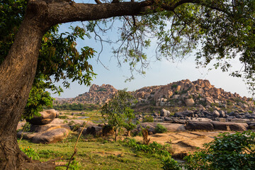 Obraz premium インド ハンピのトゥンガバドラ川沿いの風景と岩山