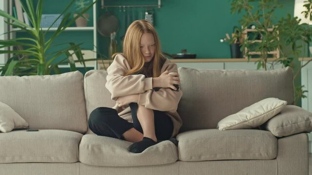 A Depressed and Desperate Red-haired Teenage Girl in Stress, Holding a Bottle of Pills. The Problem of Bullying, Psychological Abuse in Social Networks. Cyberbullying. Mental Health.